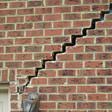stair step cracking reaching from a window along the foundation wall in San Jose