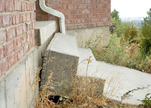 A sinking front step and cracked concrete sidewalk in San Diego.