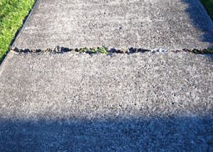 A sinking concrete sidewalk in need of mudjacking services in Los Angeles.